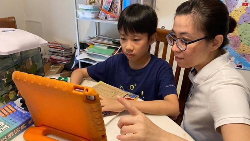 Phụ huynh Malaysia hướng dẫn con học trực tuyến tại nhà.