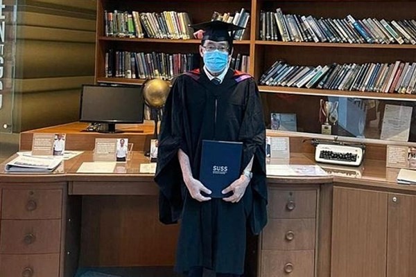 Ông Aw Yong mặc trang phục cử nhân nhận bằng tốt nghiệp.