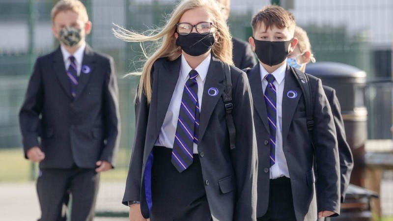 Học sinh Anh đeo khẩu trang đến trường.