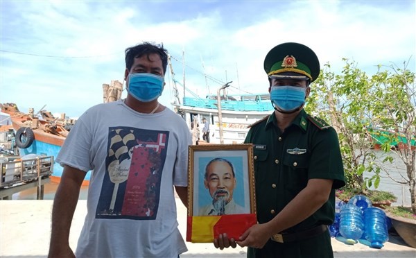 Ngư dân Ngô Văn Bông trú tại xã Bình Thắng phấn khởi khi được cán bộ Biên phòng tặng ảnh Bác Hồ và cờ Tổ quốc trước khi ra khơi.