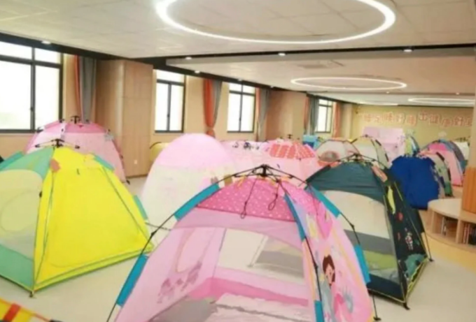 Học sinh Trường Xingfuhe dựng lều ngủ tại hội trường lớn.