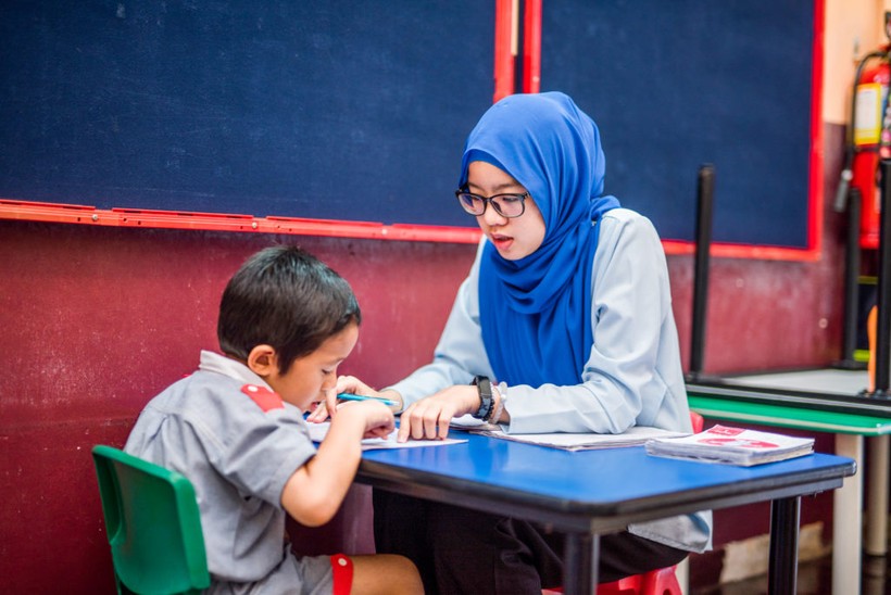 Một trẻ mẫu giáo tại Malaysia đang tập đọc, viết.