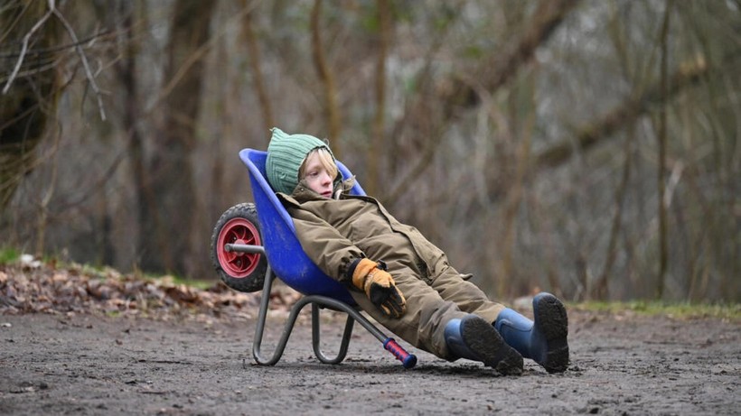 Một cậu bé nghỉ ngơi sau khi vui chơi trong rừng ở Ballerup, Đan Mạch.