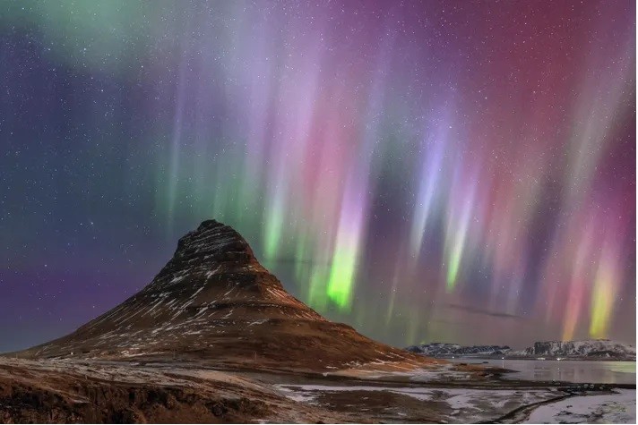 Cực quang thắp sáng bầu trời đêm Kirkjufell, một ngọn núi ở Iceland. Ảnh: Babak Tafreshi