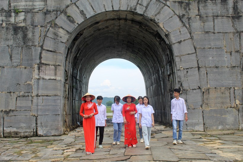 Cô và trò Trường THPT Vĩnh Lộc được hướng dẫn viên du lịch (bìa trái) giới thiệu về di sản Thành Nhà Hồ. ảnh 2