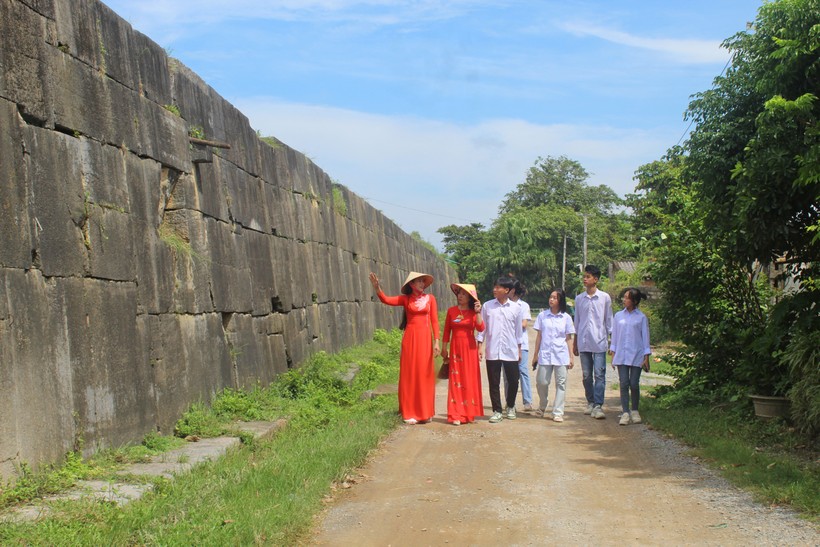 Hướng dẫn viên (bìa trái) giới thiệu về bức tường bằng đá bao quanh Thành Nhà Hồ. ảnh 8