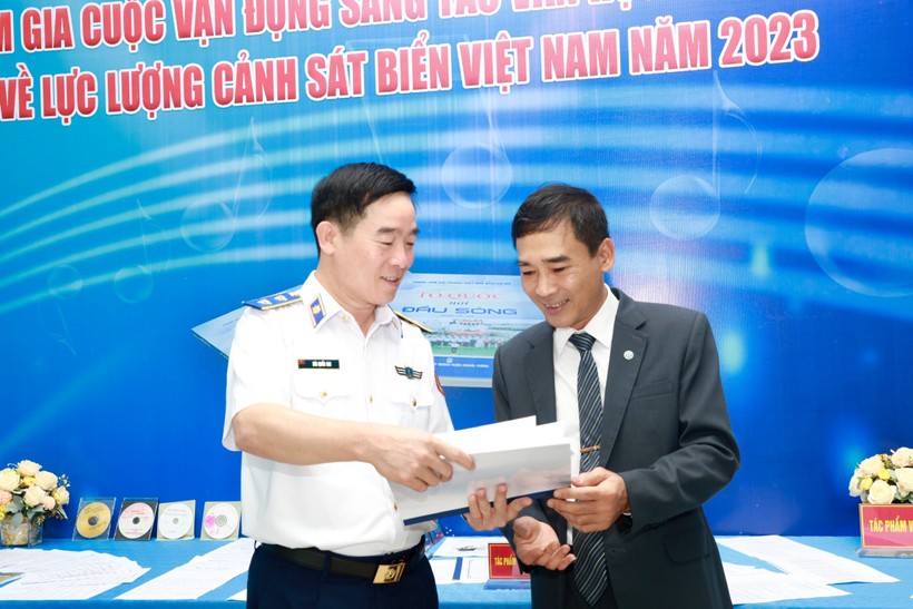 Trung tướng Bùi Quốc Oai - Chính ủy Cảnh sát biển Việt Nam trao đổi với nhà thơ Trần Khánh Toàn (phải) những chi tiết tâm đắc, thú vị trong cuốn tiểu thuyết 'Biển bây giờ vẫn khát'. 