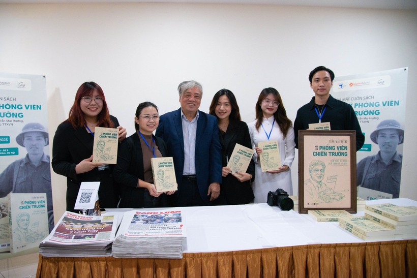 Nhà báo Trần Mai Hưởng chụp ảnh lưu niệm với các bạn trẻ sau khi đã ký tặng sách. Ảnh: Thảo Quyên.