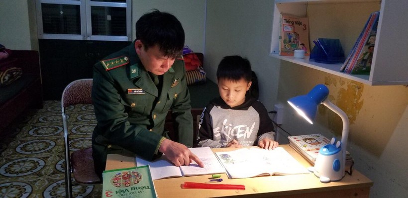 Chiến sĩ Đồn Biên phòng Đức Long hướng dẫn 'con nuôi' học bài buổi tối.