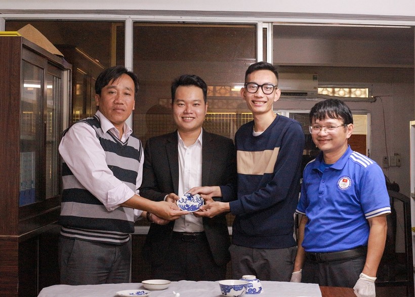 Sinh viên Hoàng Việt Anh (thứ 2 từ phải qua trái) trao tặng hiện vật cho ông Trương Quý Mẫn (ngoài cùng, bên trái) – Phó Giám đốc Bảo tàng Cổ vật Cung đình Huế. (Ảnh: Hoàng Hải).