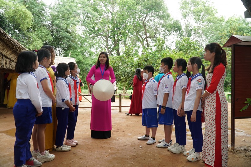 Học sinh Trường Tiểu học Hoàng Trù (xã Kim Liên, Nam Đàn, Nghệ An) đến thăm quê nội Bác Hồ và lắng nghe cô thuyết minh kể chuyện về gia đình Người.