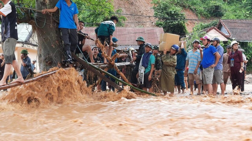 Lực lượng địa phương, thầy cô, người dân làm cầu tạm qua suối để đón gần 60 học sinh THPT Kỳ Sơn bị mắc kẹt trong bản Sơn Hà, xã Tà Cạ ra ở ký túc xá trong trường.