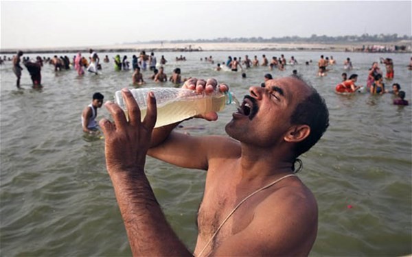 Người đàn ông ở Allahabad uống nước từ dòng sông Hằng linh thiêng.