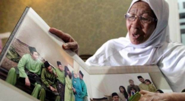 Bà Jamillah xem lại album ảnh gia đình con trai, những người vừa tử nạn trên chuyến bay MH17. Ảnh: Malay Mail