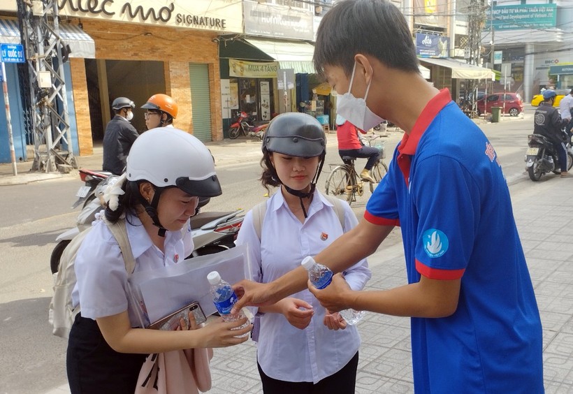 Thanh niên tình nguyện phát nước cho thí sinh tại điểm thi Trường THCS Trưng Vương. Ảnh: NTCC