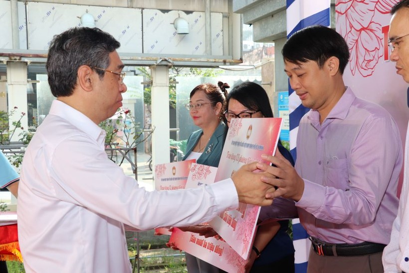Phó Bí thư Thành ủy TPHCM Nguyễn Phước Lộc trao bảng tượng trưng hỗ trợ chăm lo người nghèo cho quận, huyện. (Ảnh: Ủy ban Mặt trận Tổ quốc TPHCM) ảnh 1
