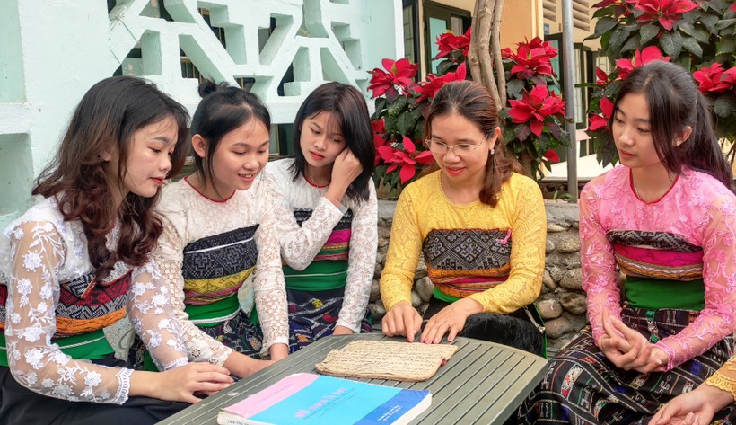 Cô giáo Hà Thị Khuyên đang hướng dẫn cho học trò của mình cách học chữ Thái. Ảnh: TL
