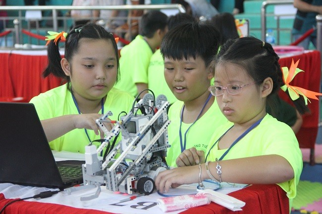Các em học sinh chăm chú  lập trình robot