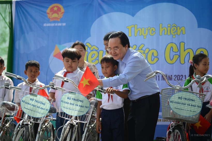 Bộ trưởng Bộ GD&ĐT Phùng Xuân Nhạ trao xe đạp cho các em học sinh hoàn cảnh khó khăn. Ảnh: Thế Đại.