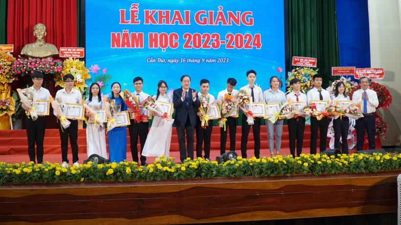 GS.TS Nguyễn Thanh Phương - Bí thư Đảng ủy, Chủ tịch Hội đồng Trường (bìa phải) và GS.TS Hà Thanh Toàn, Hiệu trưởng khen thưởng 13 tân SV đạt điểm cao vào trường.
