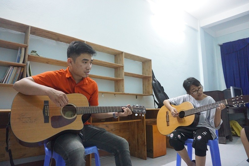 Các em nhỏ bị khiếm khuyết cơ thể được anh Hoàn dạy học đàn guitar. 