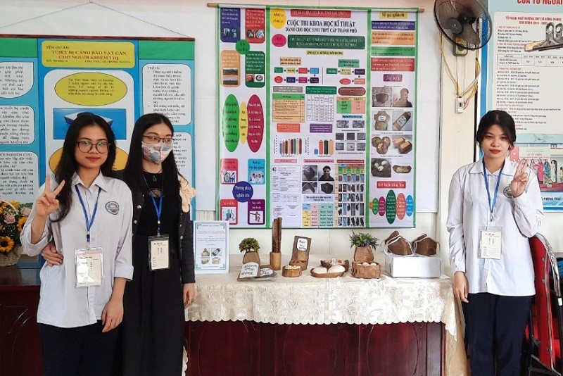 Hai nữ sinh cùng cô giáo Hương trong gian trưng bày sản phẩm.