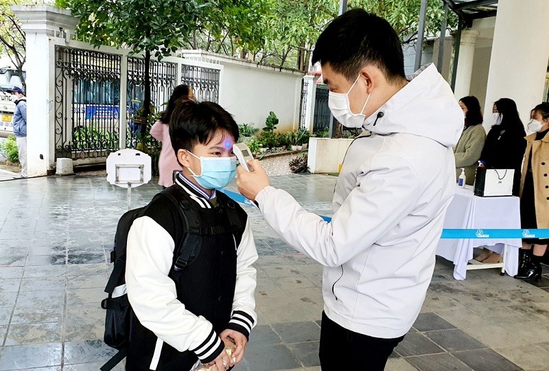 Học sinh Trường THCS-THPT Ban  Mai (Hà Đông, Hà Nội) đo thân nhiệt trước khi vào lớp học. 