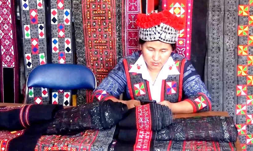 Chị Tráng Thị Cầu - Chủ nhiệm CLB Thêu may trang phục dân tộc Mông (xã Nà Bủng, huyện Nậm Pồ) trao đổi thông tin trực tuyến với khách hàng.