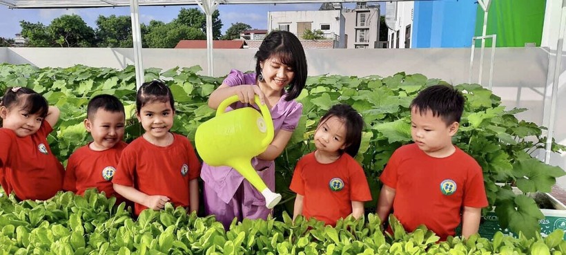 Cô Nguyễn Thùy Dung cùng trẻ chăm sóc vườn rau xanh.
