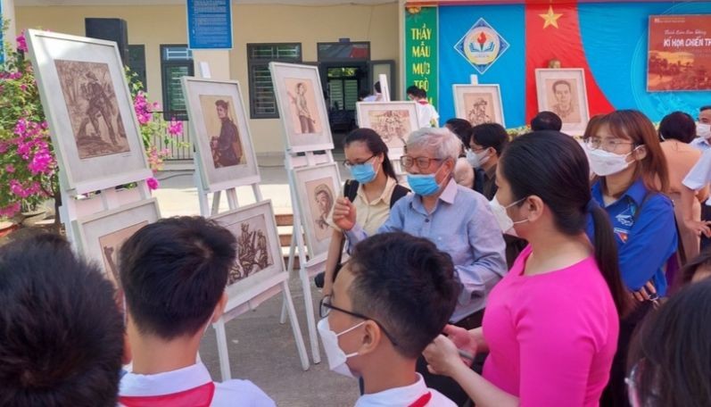 Học sinh Trường THCS Nguyễn Văn Linh (Hòa Vang) nghe họa sĩ - nhà điêu khắc Phạm Hồng - nhân chứng trực tiếp tham gia chiến đấu tại chiến trường khu V kể chuyện tại triển lãm Ký họa chiến trường.