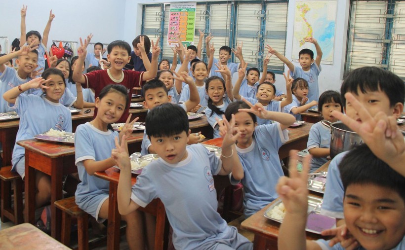 Học sinh Trường Tiểu học Nguyễn Thị Minh Khai hào hứng trong bữa ăn bán trú. ảnh 1