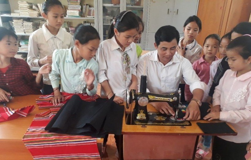 Thầy Nguyễn Văn Hùng, Phòng GD&ĐT huyện Than Uyên (Lai Châu) hướng dẫn học sinh CLB Khâu thêu, bảo tồn, phát huy bản sắc văn hóa của các dân tộc, gắn liền với nhiệm vụ giáo dục dân tộc. Ảnh: NVCC