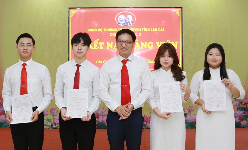 Thầy Ngô Thanh Xuân, Bí thư Đảng bộ, Hiệu trưởng Trường THPT chuyên Lào Cai, trao Quyết định kết nạp đảng viên cho 4 học sinh.