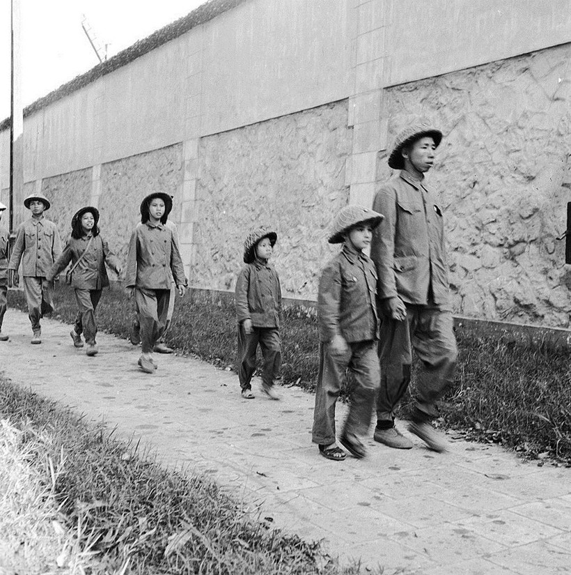 Một gia đình đi ngang qua khu vực nhà tù Hoả Lò trên đường đi xem diễu binh sau ngày Chính phủ Việt Minh về tiếp quản năm 1954. ảnh 2