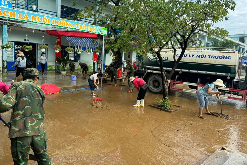 Bộ đội hỗ trợ cho giáo viên Trường Tiểu học Hồng Quang thau dọn lượng lớn bùn non đọng lại trên sân trường và các lớp học sau cơn mưa lớn ngày 7/11. Ảnh: TG