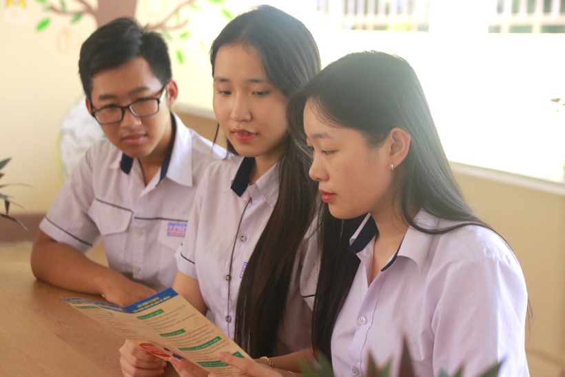 Học sinh TP Buôn Ma Thuột tìm hiểu thông tin về SKSS vị thành niên qua tờ rơi của ngành y tế. Ảnh: Thành Tâm