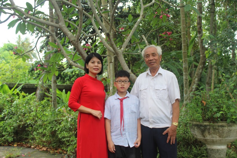 Nhà giáo Bùi Khắc Thái cùng cháu nội và con dâu Lê Thị Dung. Ảnh: Lường Toán