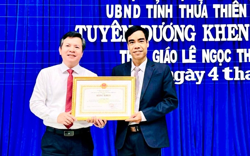 Ông Nguyễn Tân (bên trái) - Giám đốc Sở GD&ĐT tỉnh Thừa Thiên Huế thừa ủy quyền trao Bằng khen của Bộ trưởng Bộ GD&ĐT cho thầy giáo Lê Ngọc Thùy.