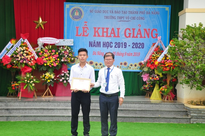 Thầy Phạm Đình Kha, Hiệu trưởng Trường THPT Võ Chí Công (bìa phải) trao thưởng cho HS có thành tích xuất sắc trong học tập