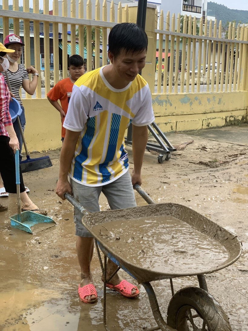 Bùn ngập sân trường, phụ huynh Trường Tiểu học Hồng Quang phải sử dụng xe rùa để thu dọn bùn đất. ảnh 2