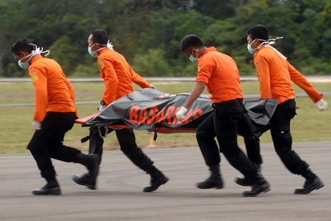 Các nhân viên cứu hộ Indonesia chuyển thi thể một nạn nhân trong vụ tai nạn máy bay QZ8501 ngày 31/12. (Nguồn: AFP/TTXVN)