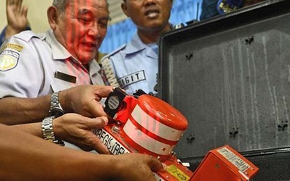 Trưởng ban An toàn Giao thông Indonesia Tatang Kurniadi xem xét hộp đen máy bay QZ8501. Ảnh AP