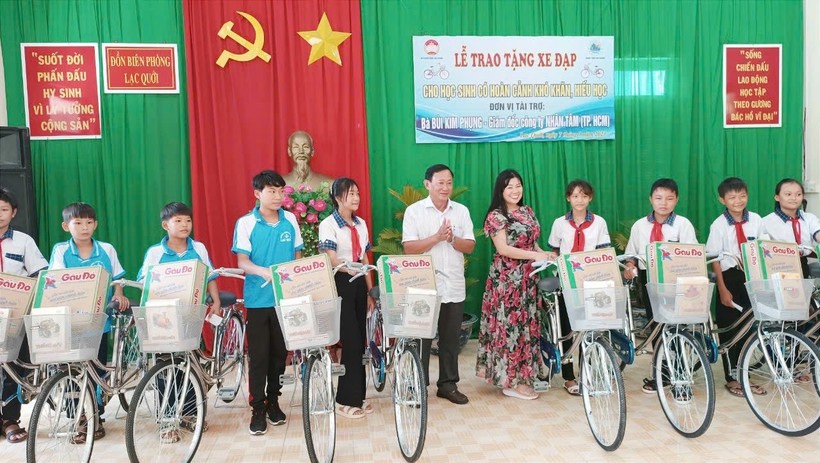Ông Nguyễn Tiếc Hùng - Chủ tịch Ủy ban MTTQ Việt Nam tỉnh An Giang và nhà tài trợ trao xe đạp và quà cho học sinh. ảnh 1