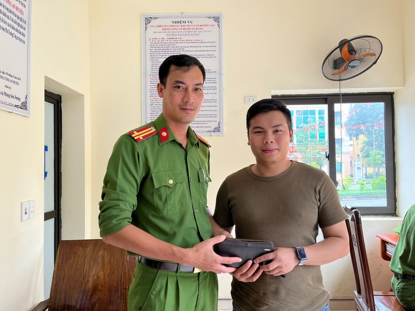 Trung tá Nông Văn Quốc trao lại tiền và giấy tờ cho anh Tiệp. Ảnh: Công an huyện Na Hang