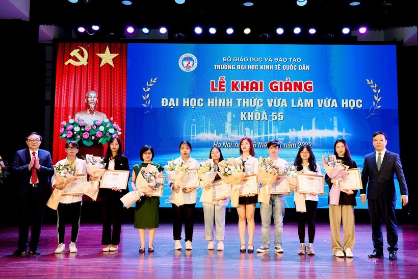 PGS.TS Bùi Huy Nhượng - Phó Hiệu trưởng, PGS.TS Phạm Quang - Trưởng khoa ĐH Tại chức trao giấy khen và tặng hoa cho các tân sinh viên. 