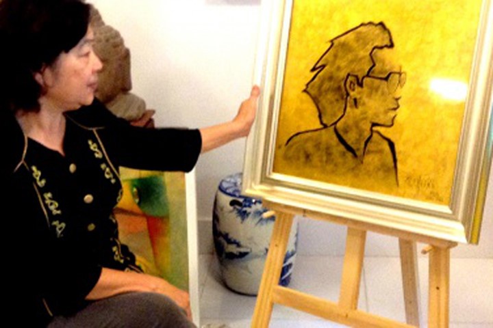 Nhà thơ Đỗ Bạch Mai bên cạnh bức tranh nhà thơ Bế Kiến Quốc do họa sĩ Thành Chương vẽ