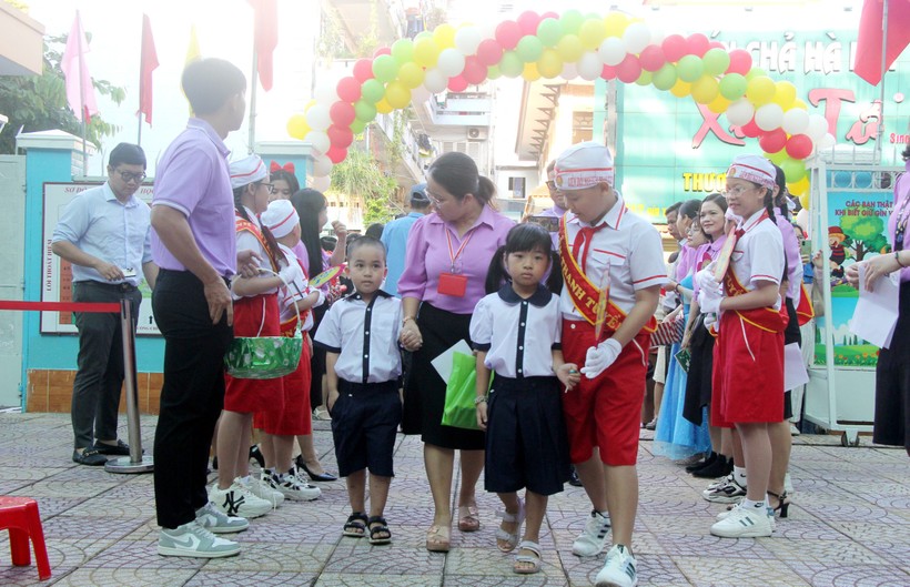 Giáo viên và các bạn Liên đội Trường tiểu học Nguyễn Thanh Tuyền đón học sinh từ cổng trường.
