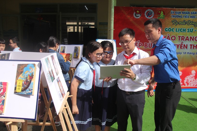 Giáo viên Trường tiểu học Phú Thọ hướng dẫn học sinh sử dụng mã QR để khai thác tư liệu. ảnh 2