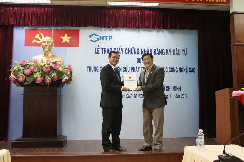 Ông Lê Hoài Quốc (bên phải) trao giấy chứng nhận đầu tư cho PGS.TS Nguyễn Văn Phúc- Hiệu trưởng Trường ĐH Mở TPHCM