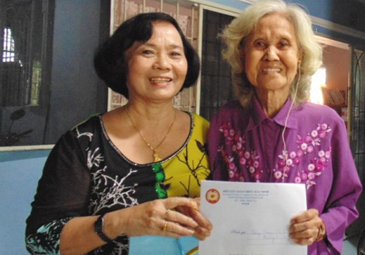Bà Văn Thị Cưng - Chủ tịch hội (bên trái) - trao quà cho gia đình cô giáo Nguyễn Thị Hồng Vân ở phường 3, TP. Tây  Ninh.